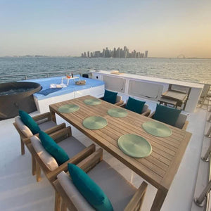 Luxury houseboat docked in Qatar featuring spacious decks, a Jacuzzi, and outdoor seating for a relaxing sea escape.