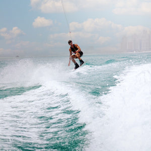 Wide shot of the wakeboarding adventure showing speed, balance, and the scenic Qatar coastline.